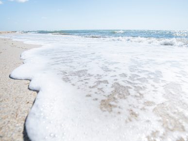 Nisipul acoperit de spuma valurilor Marii Negre